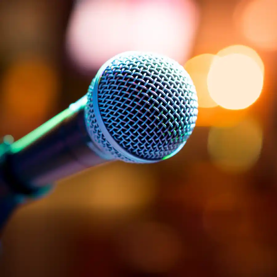 Image of microphone with abstract theatre lights in the background
