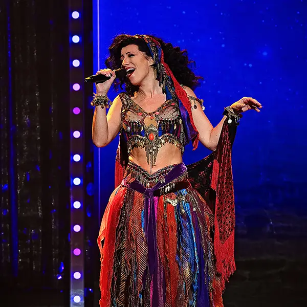 A woman singing onstage in an elaborate costume